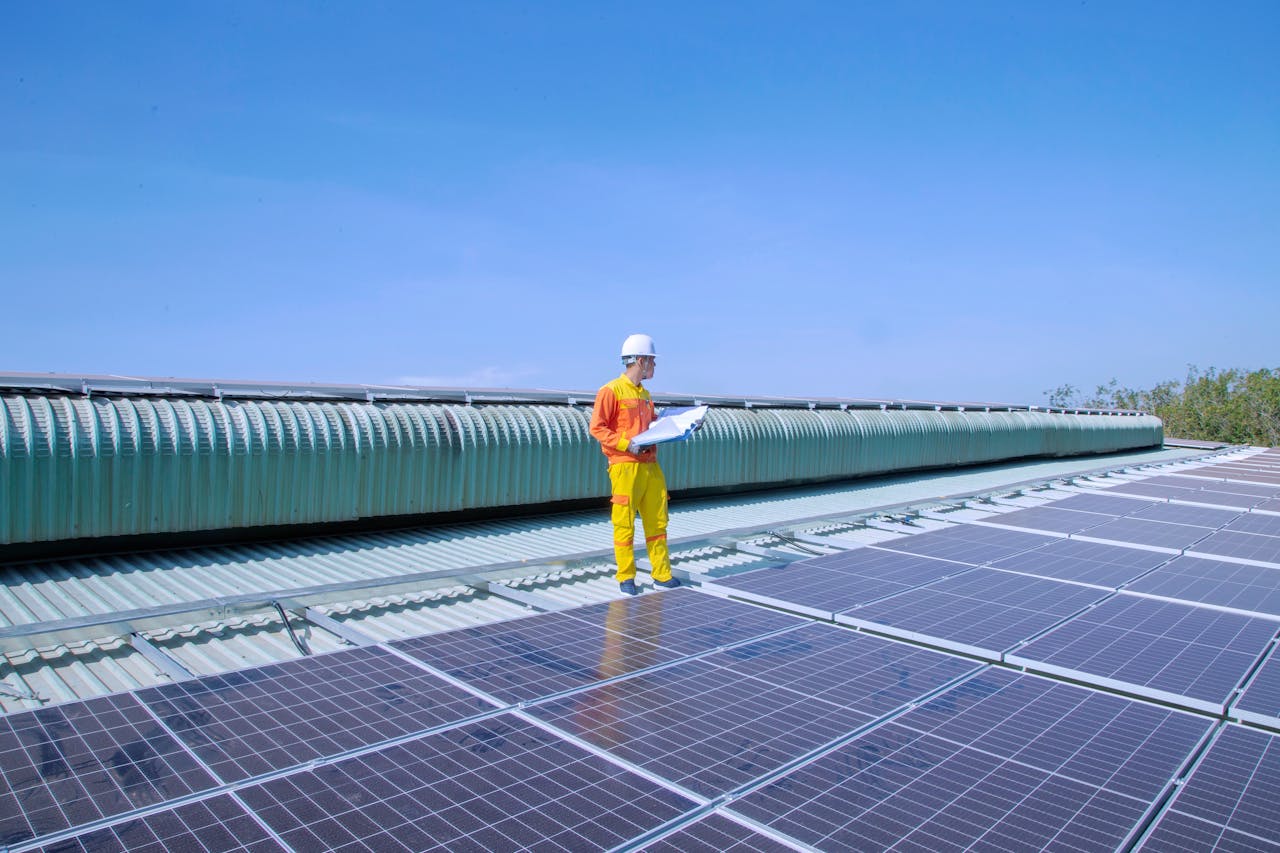 Technician examining solar panels on a rooftop, emphasizing renewable energy.